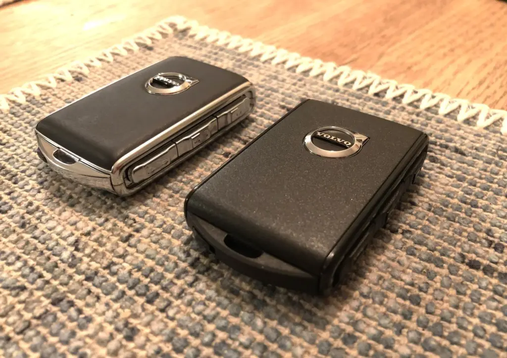 Two Volvo car key fobs placed on a woven mat